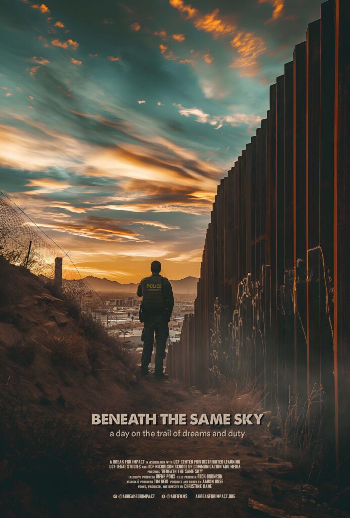 Border patrol agent standing next to the border wall in El Paso Texas.